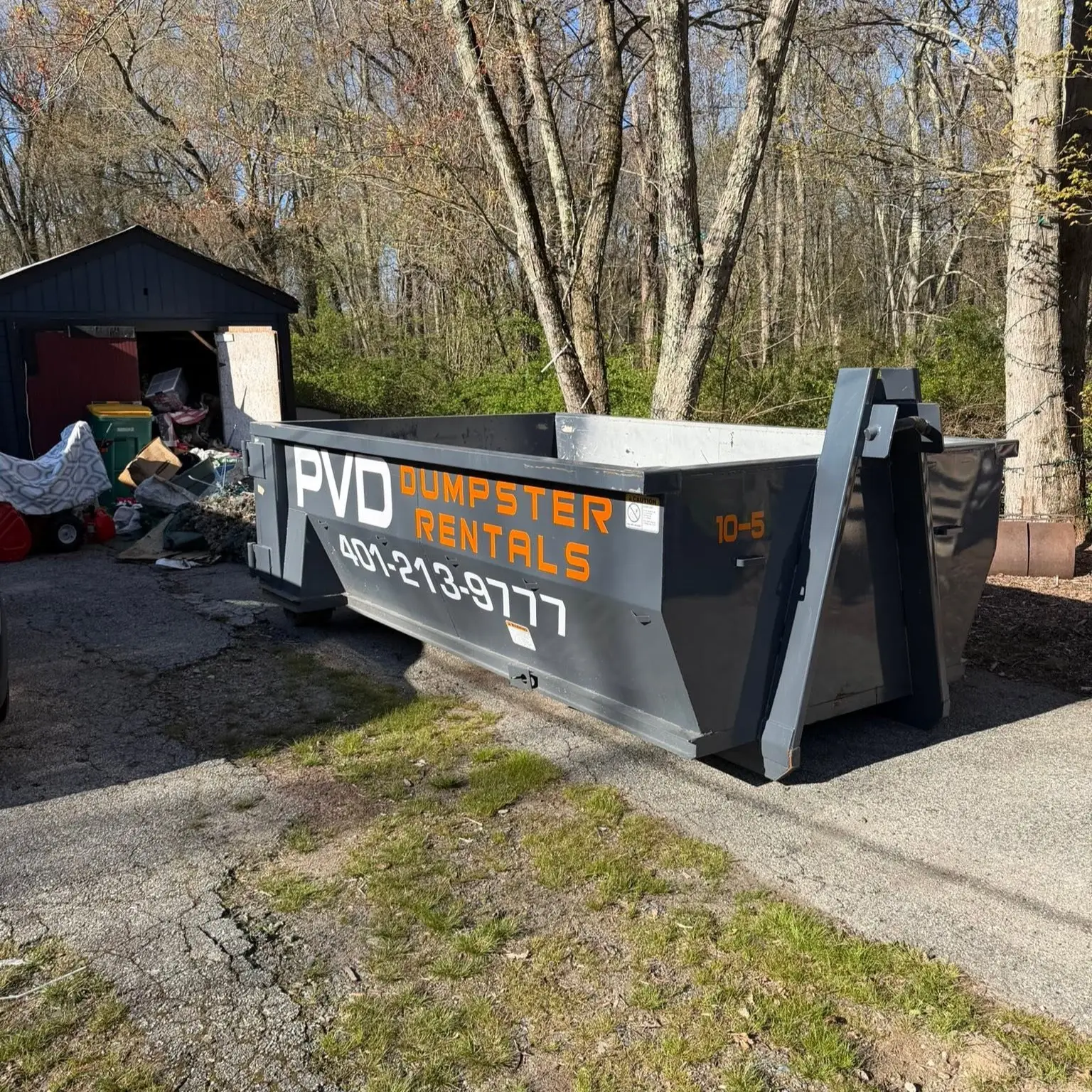 10 yard dumpster positioned at the garage door on a garage cleanout job in Cranston