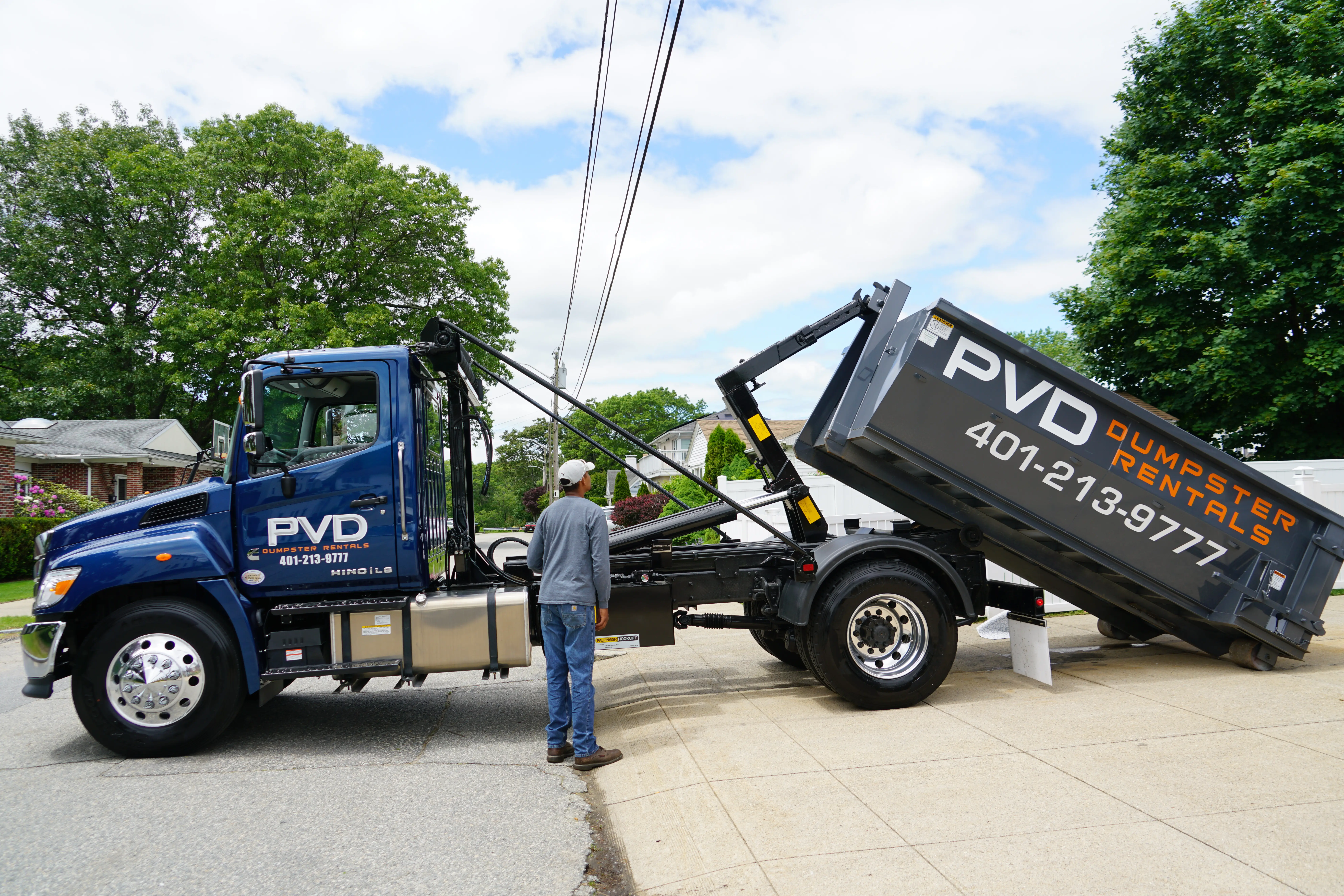 Driver unloading a 15 yard dumpster from the truck in Rhode Island