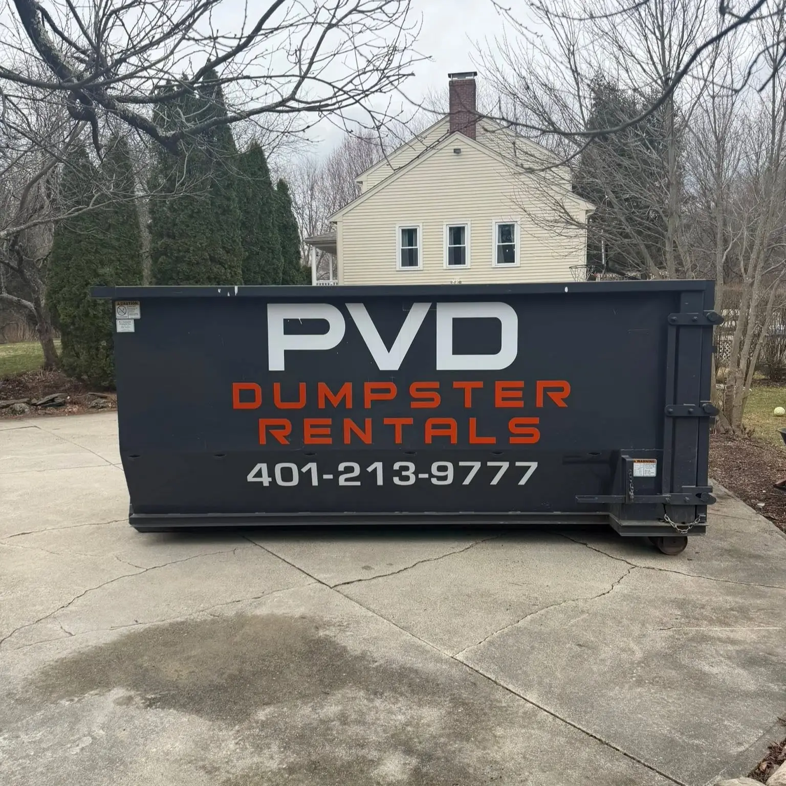 20 yard roll-off dumpster centered on a driveway in Cranston