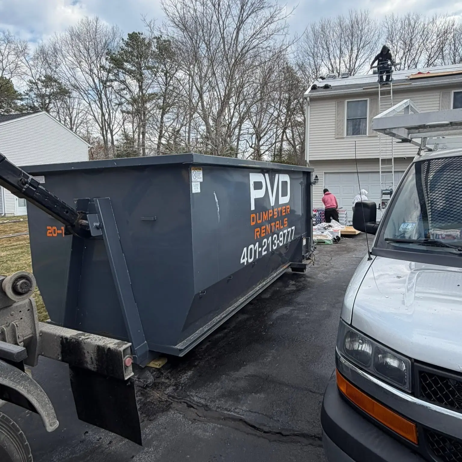 20 yard dumpster taking shingles from a tear-off on a roofing job in Cranston