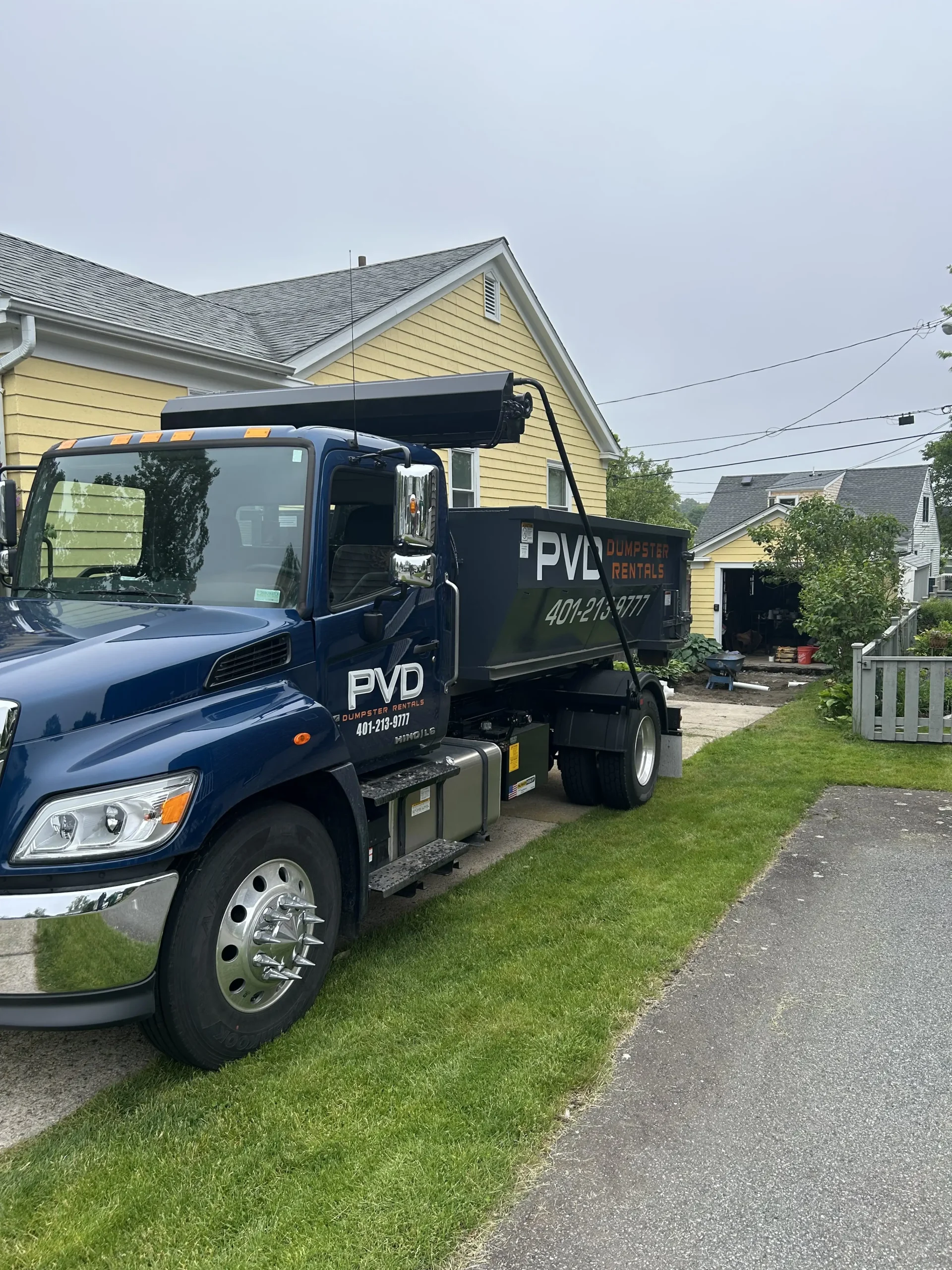 Roll-off dumpster taking furniture and boxes on an estate cleanout job in Cranston