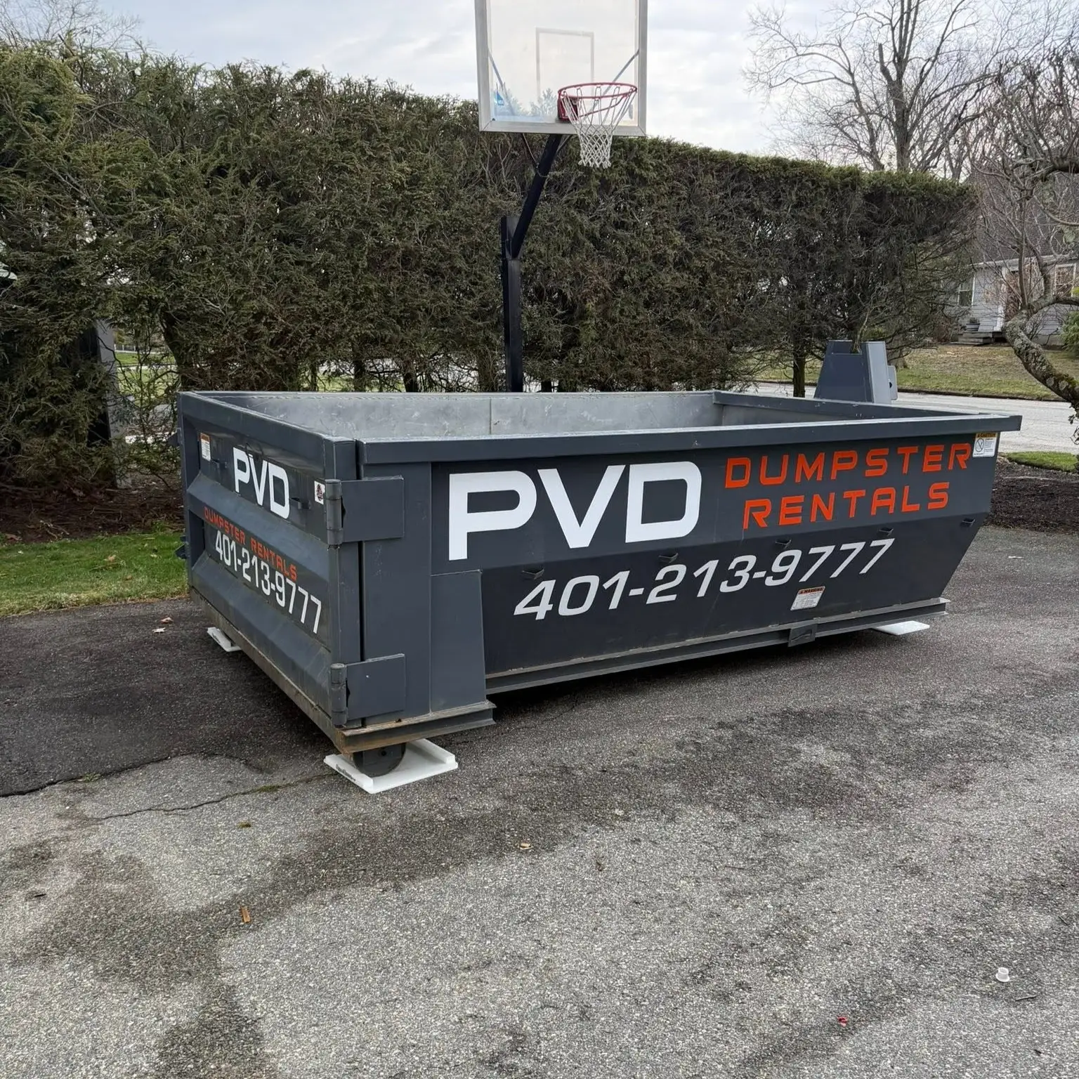 Dumpster set on driveway protection boards at a residential job in Cranston