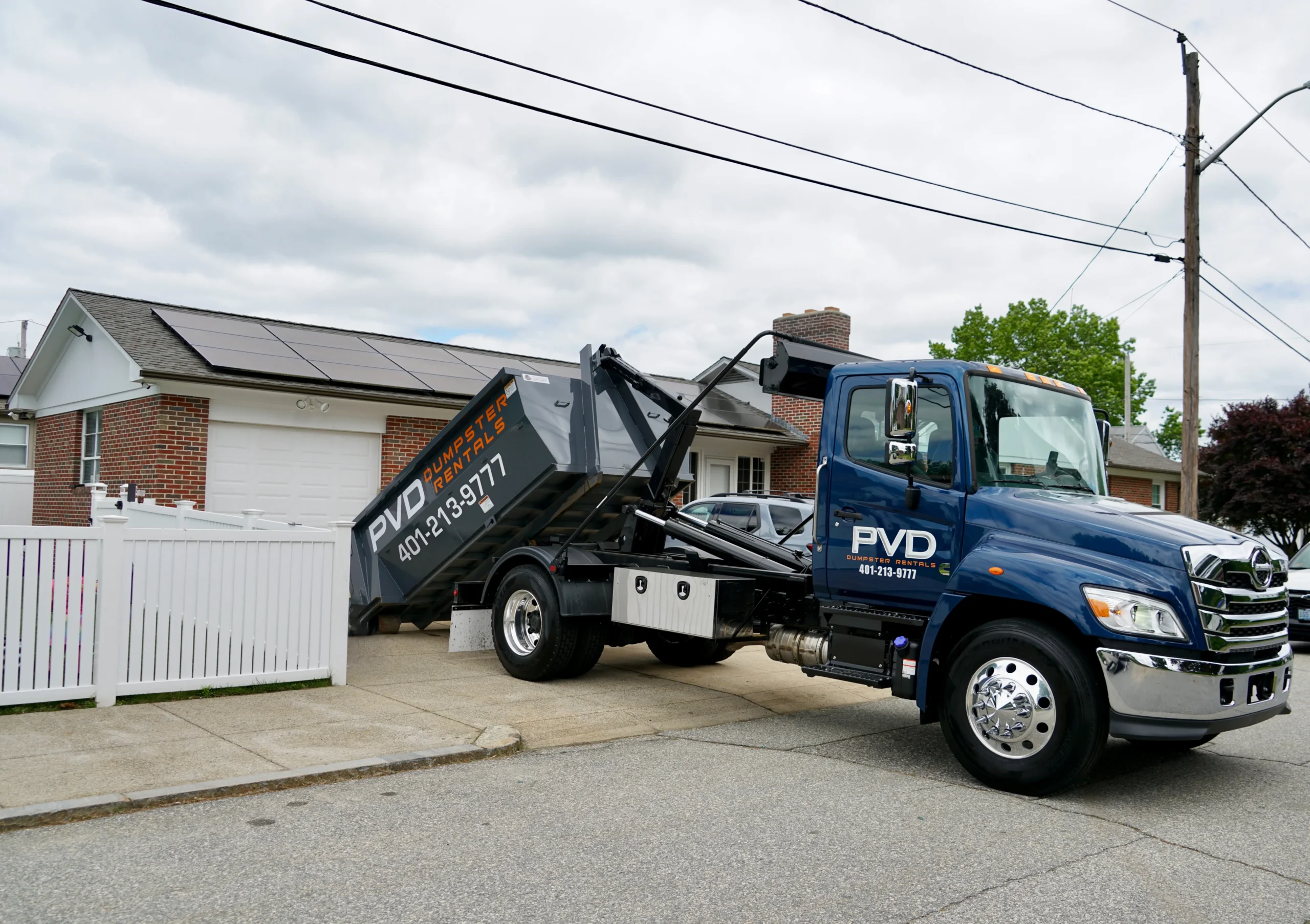 Roll-off dumpster placed in a tight residential driveway in Cranston