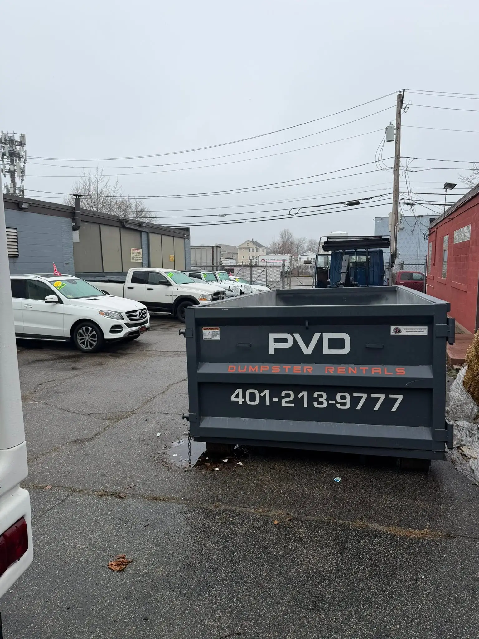 Roll-off dumpster in a commercial parking lot on a property management job in Cranston